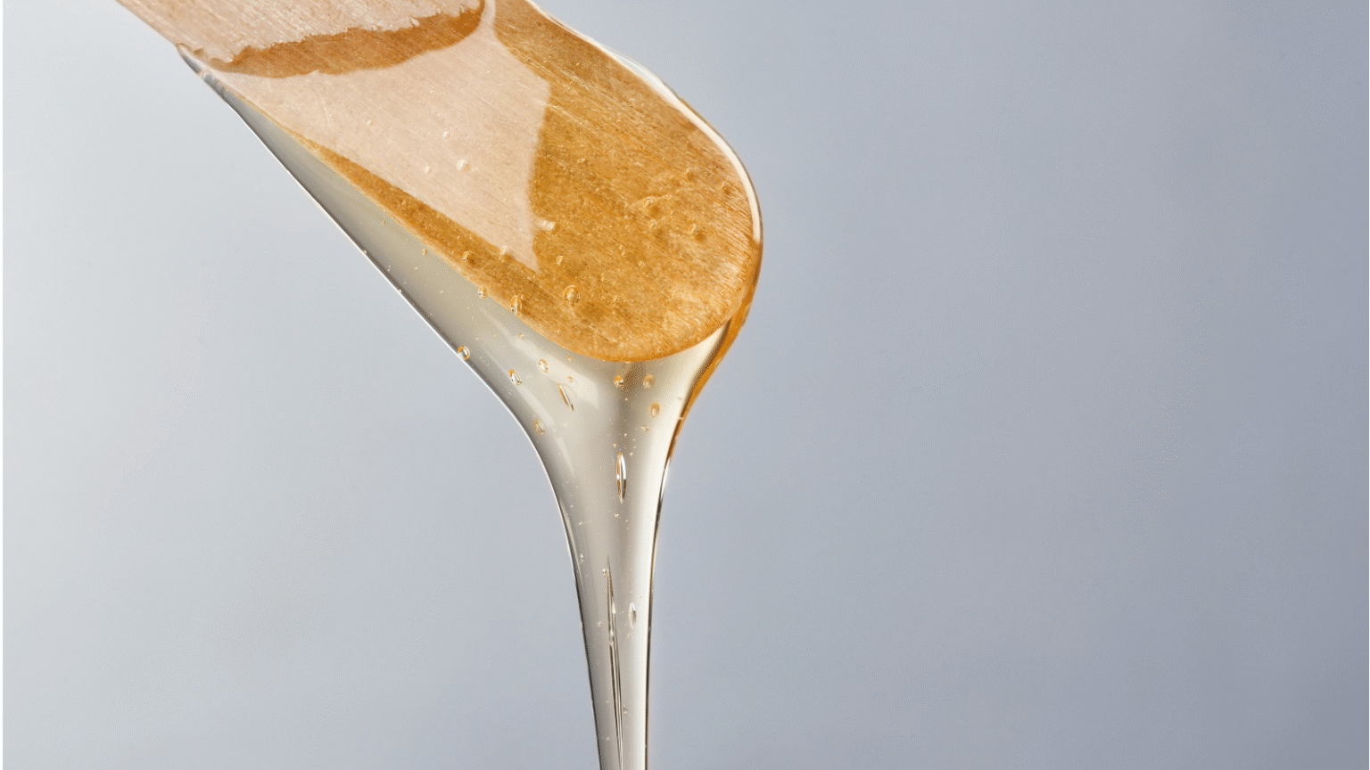 Warme wax op een spatel, klaar voor een waxbehandeling.