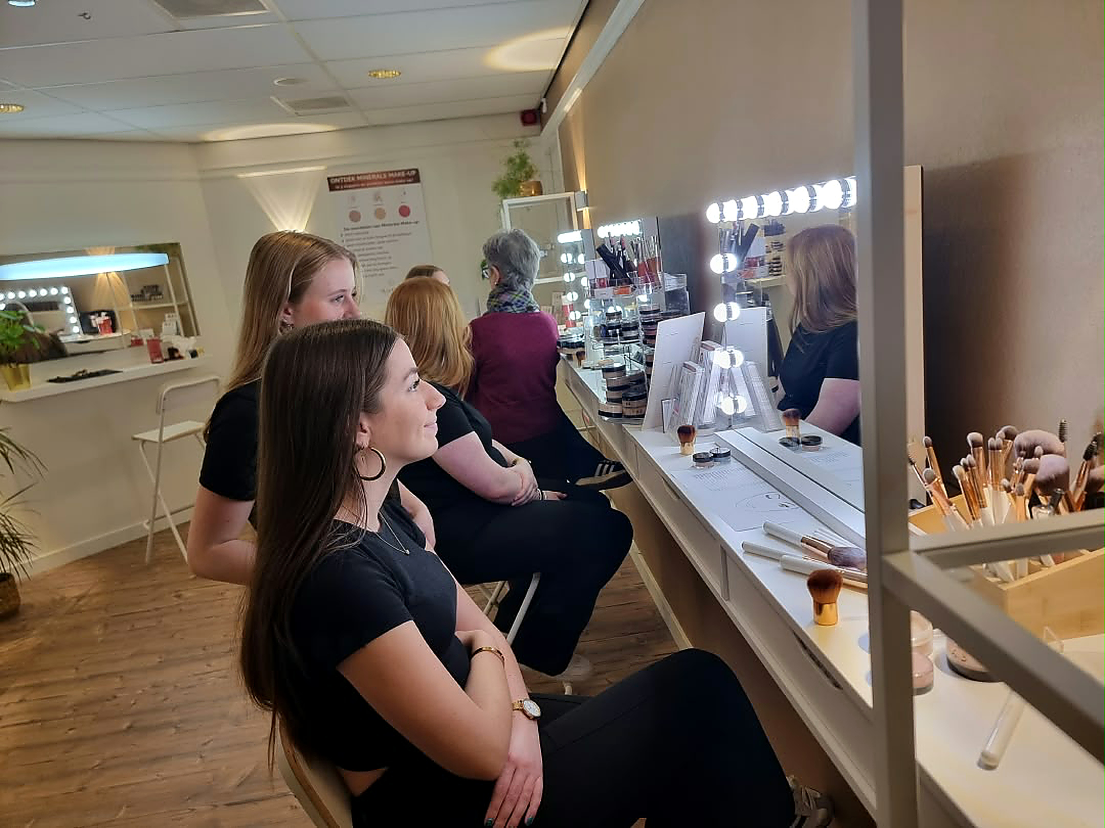 Deelnemers aan de make-up workshop bij de verlichte spiegels van Studio Rosa