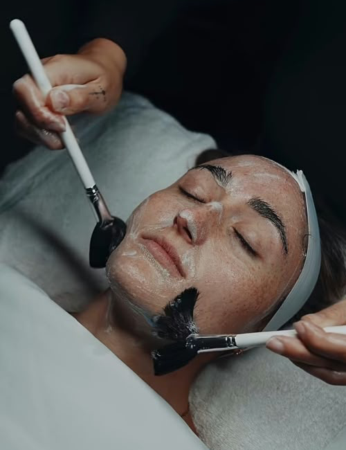 Masker wordt met een penseel aangebracht tijdens een gezichtsbehandeling.